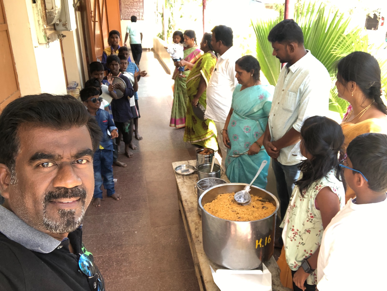 Children and community members gathering around a meal service